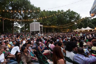 Crowds gather in Prospect Park at the Bandshell to enjoy a Celebrate Brooklyn Concert.