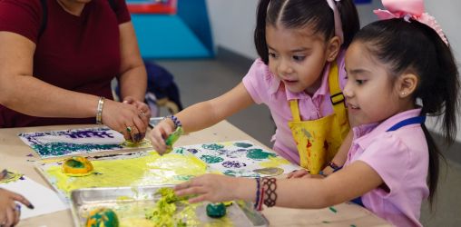 Young girls finger painting at the Brooklyn Children's Museum.